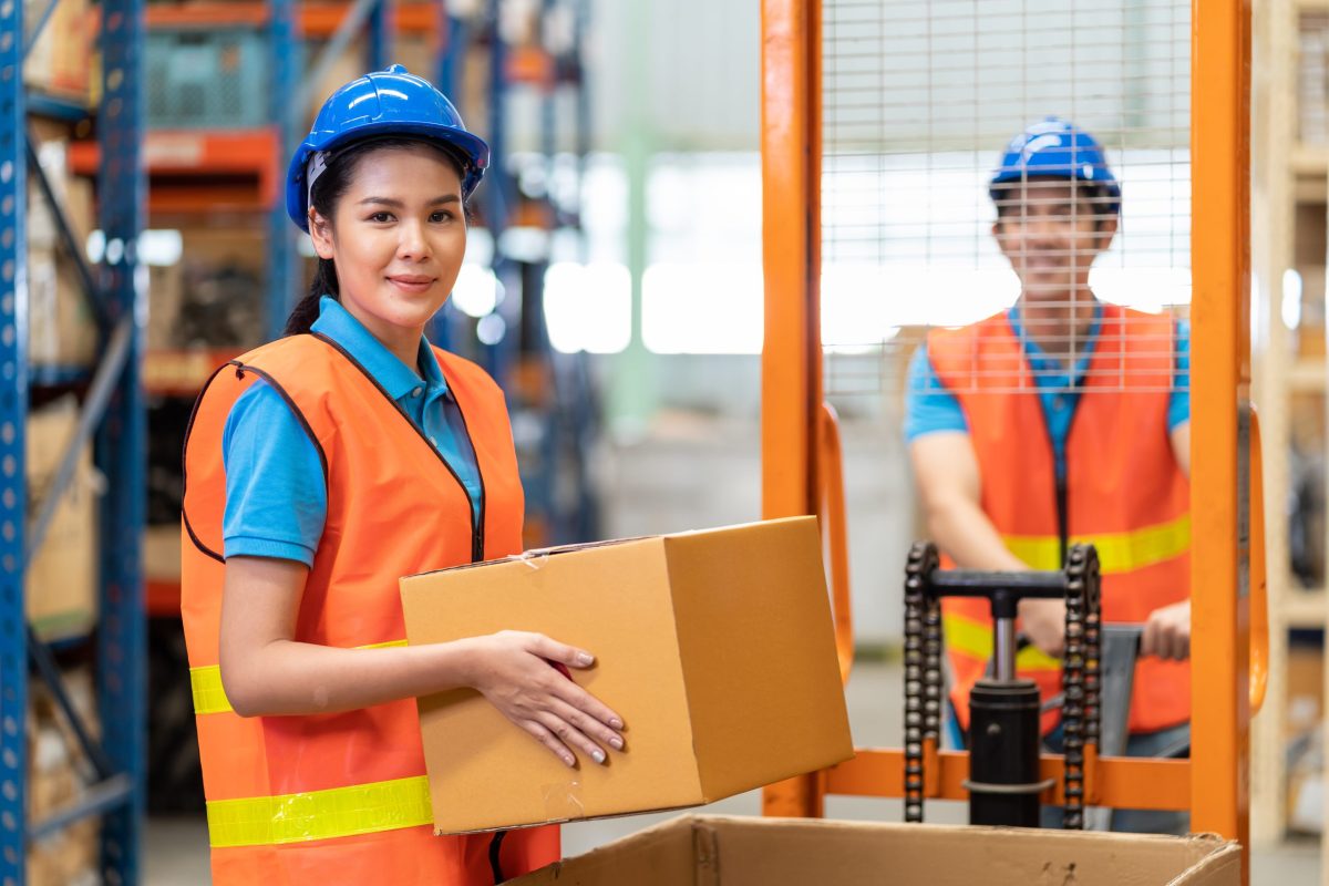 employees of a warehouse carrying box for transport